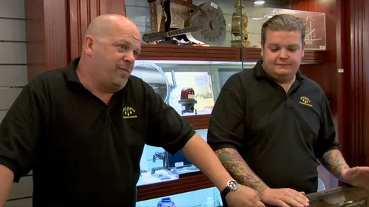Rick Harrison behind a pawn shop counter talking to a customer