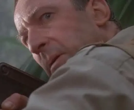 Robert Muldoon, a hunter in khaki, looking sideways in the jungle