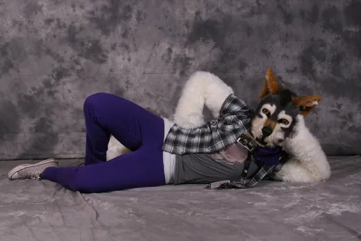 A person reclining on a sofa in a posed, dramatic way