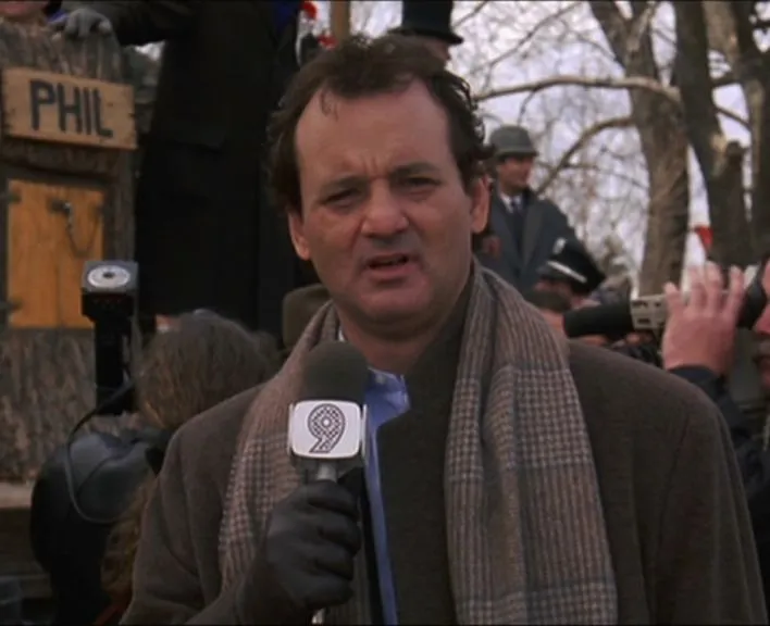 Bill Murray as weatherman Phil Connors, reporting in front of a crowd in the snow