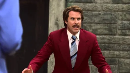 Ron Burgundy in a red suit with his arms spread, mid-speech