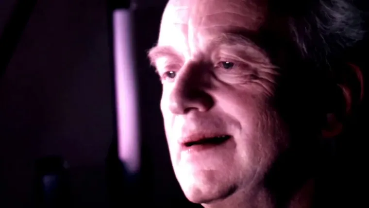 Chancellor Palpatine in a dim opera box, speaking with a knowing look