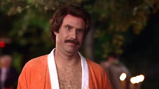 Ron Burgundy in a suit with a moustache and blow-dried hair, looking smug