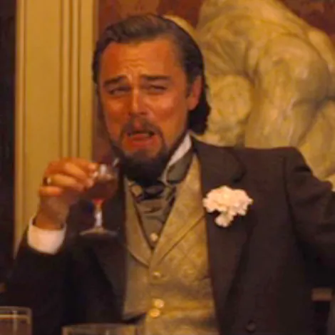 Leonardo DiCaprio as Calvin Candie, laughing and holding a glass