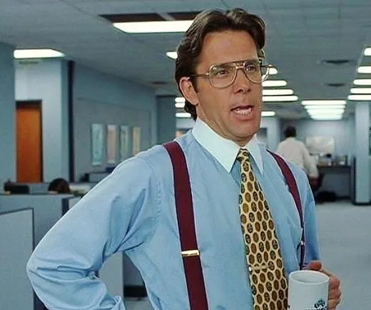 A middle-aged manager in suspenders and a tie holding a coffee mug