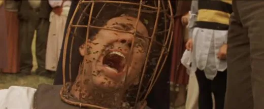 Nicolas Cage screaming with his head inside a wire mesh helmet full of bees