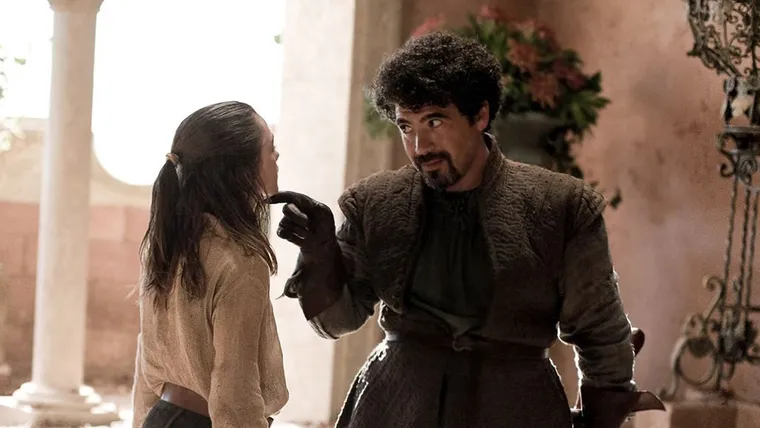 Syrio Forel, a swordmaster in leather, talking to Arya Stark in a courtyard