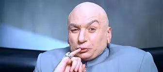Dr. Evil, bald in a grey suit, holding his little finger to the corner of his mouth