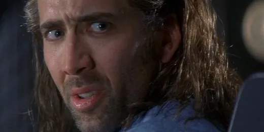 Nicolas Cage with long hair and stubble, staring intently