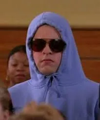 A teenager in a hoodie and sunglasses in a crowd, pointing and shouting