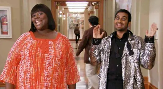 Tom Haverford and Donna Meagle walking through a mall with shopping bags, posing