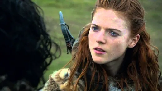 Ygritte, a red-haired wildling woman in furs, smiling in the snow